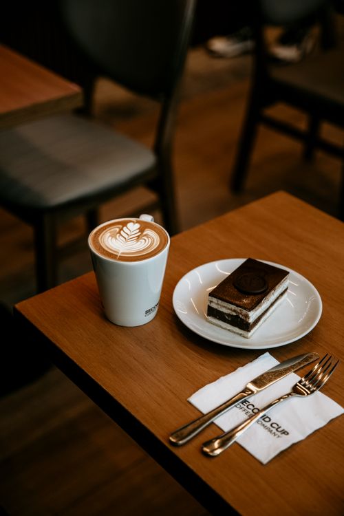 Free Delicious café latte with latte art and dessert in Baku coffee shop. Stock Photo