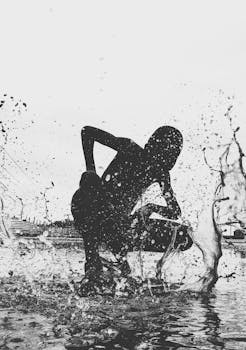 在户外，一个精力充沛的加纳人剪影创造了戏剧性的水花