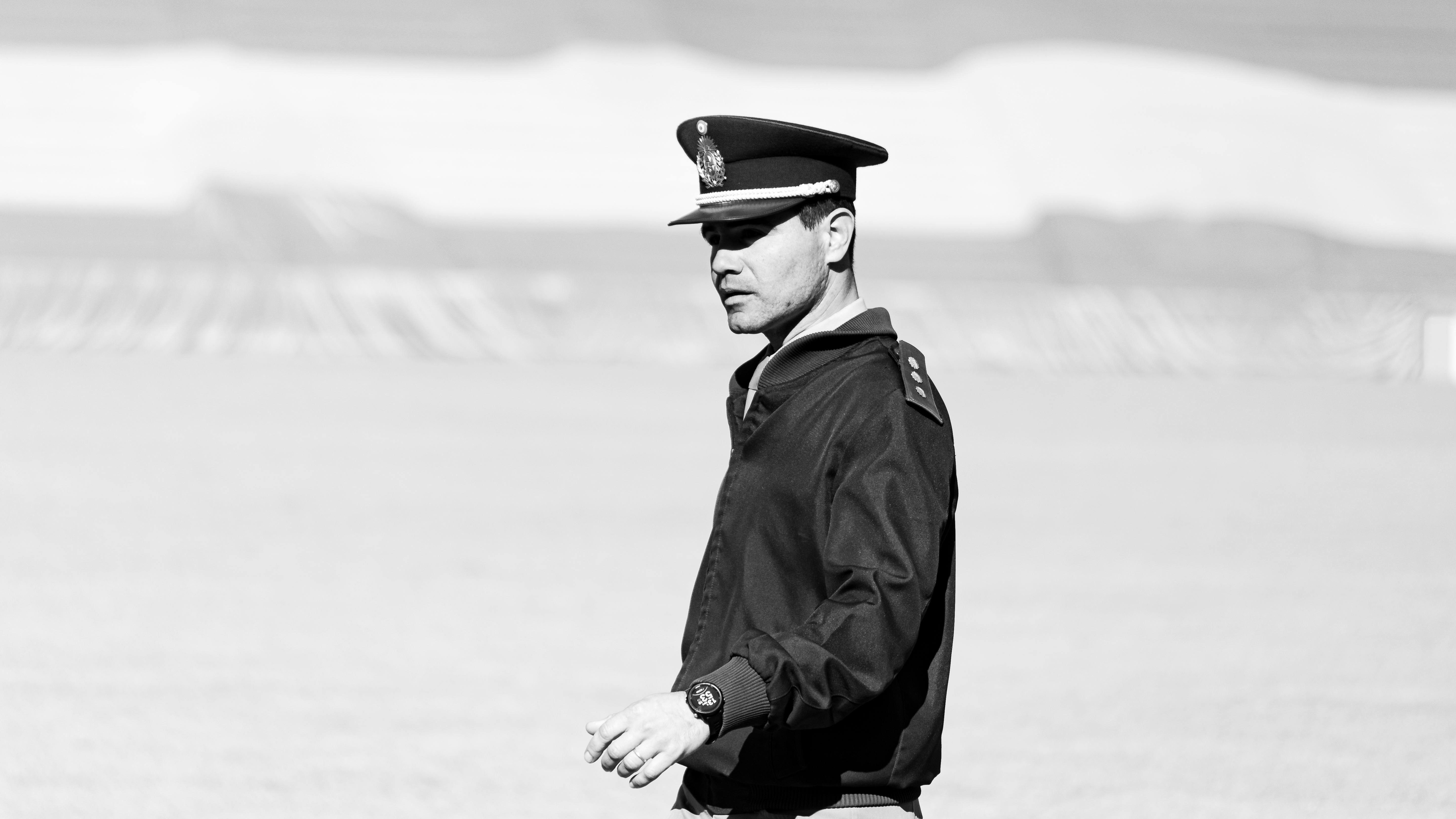 A military officer in uniform outdoors in a black and white setting.