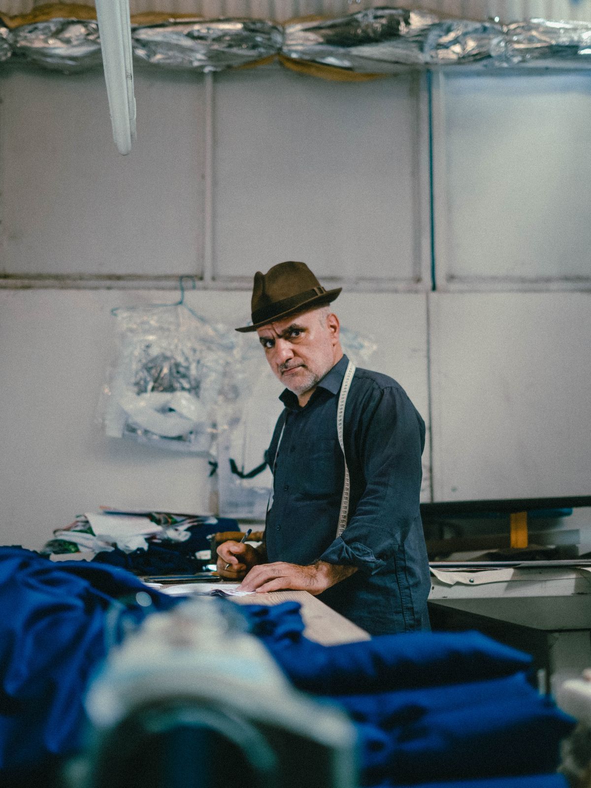 Tailor working on a suit jacket in a traditional workshop