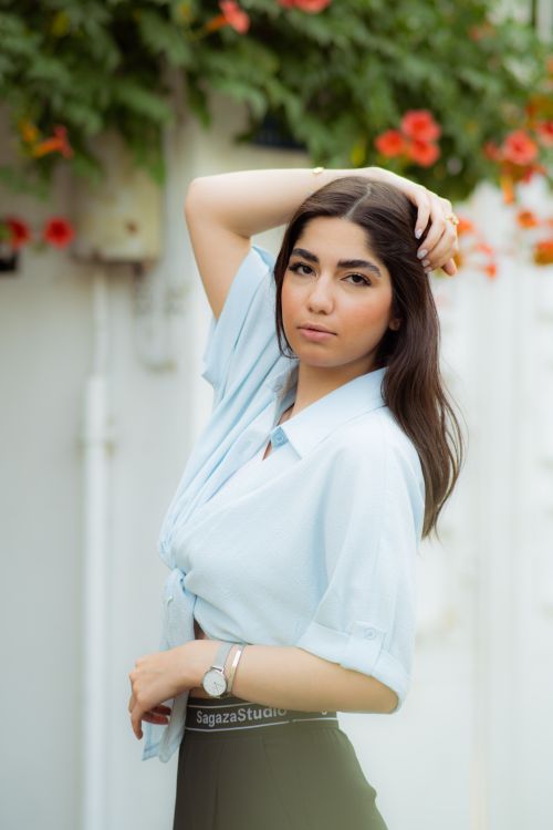 Free Elegant portrait of a woman outdoors in Gorgan with vibrant flowers. Stock Photo