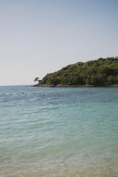 Peaceful coastal view of Ksamil, Albania featuring clear blue waters and lush greenery.