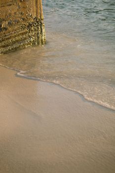 Serene beach scene in Ksamil, Albania, capturing the golden sunlight at sunset with gentle waves.