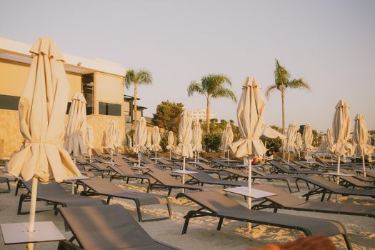 Relaxing beach scene in Ksamil, Albania with loungers and umbrellas at sunset.