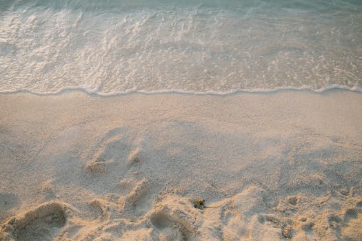 Experience the tranquil beauty of Ksamil's sandy shoreline at sunset, offering a peaceful and idyllic coastal retreat.