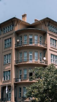 Classic architecture featuring multi-story building with balconies and a tree in foreground.