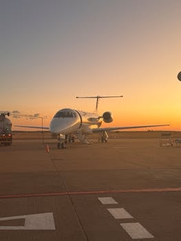 A private jet on the tarmac during a stunning sunset. Ideal for travel and aviation themes.