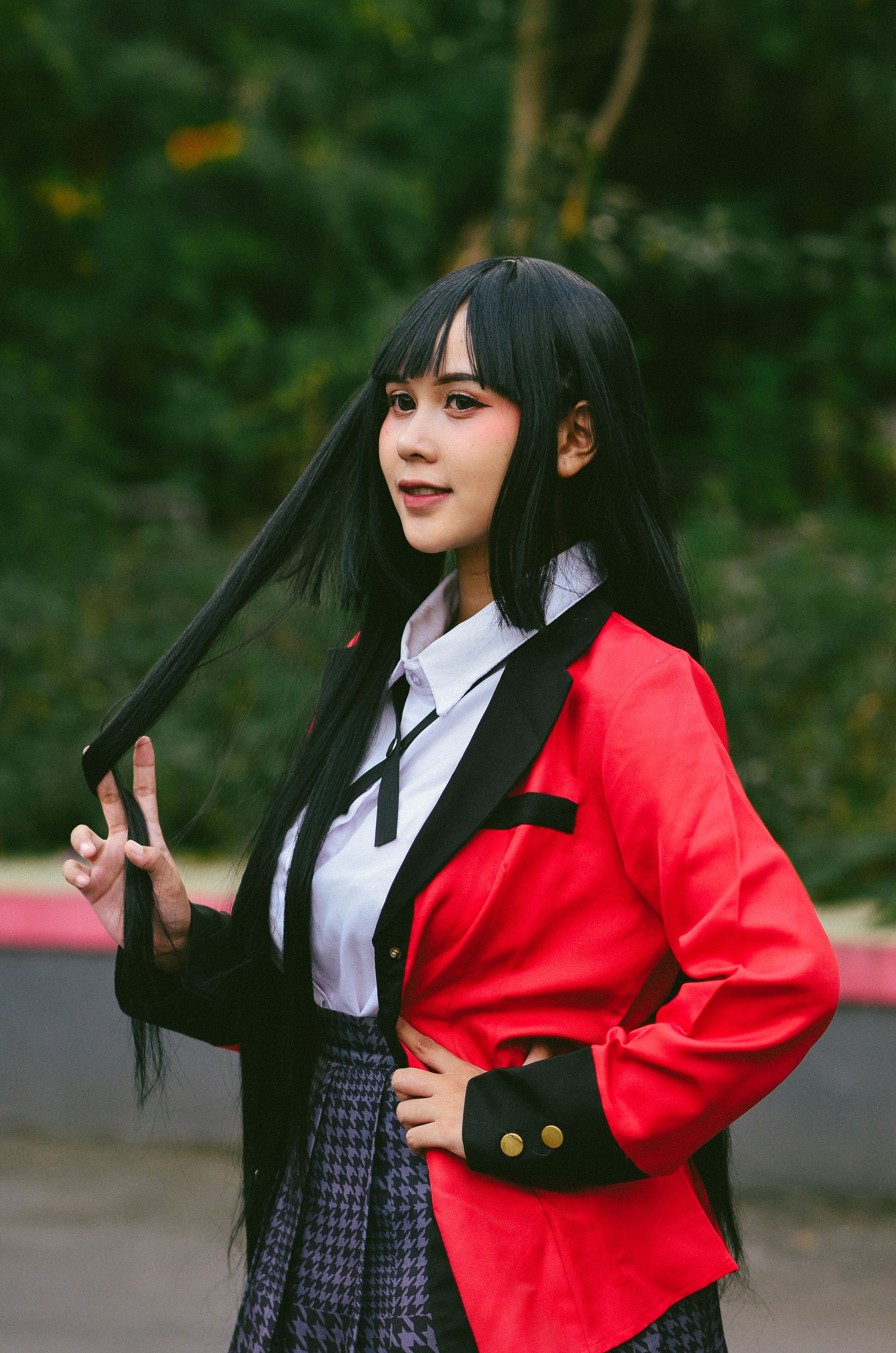Asian Cosplayer in Red Jacket Strikes a Pose Outdoors