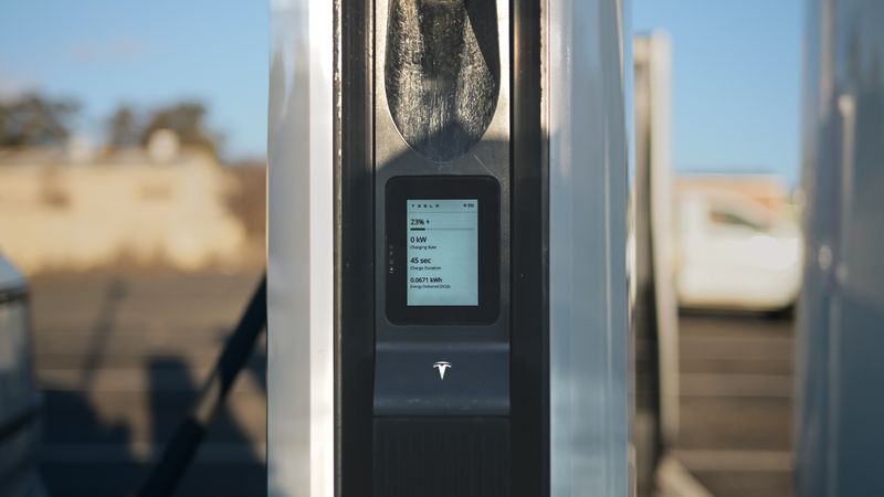 close up of an electric vehicle charging screen displaying electricity usage and range