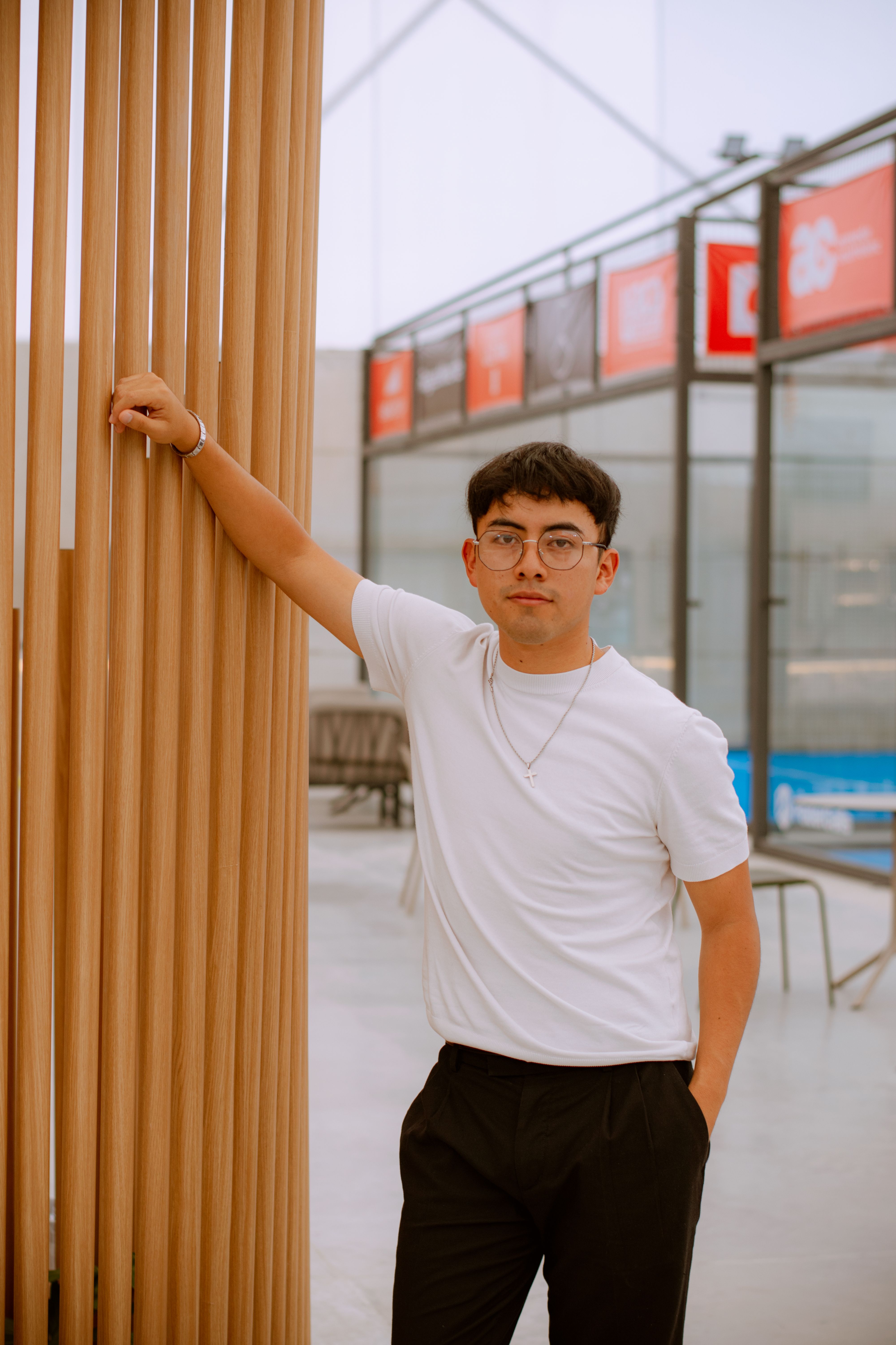 Young Hispanic man poses confidently indoors with a modern design in Puebla, Mexico.