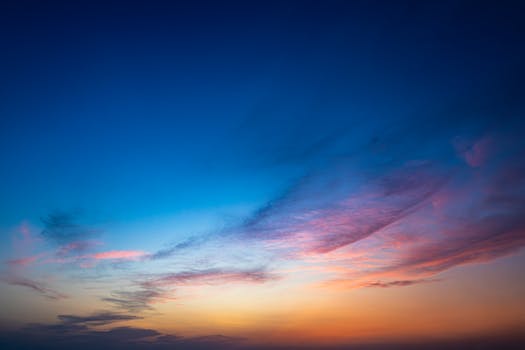Captivating sunset displaying vibrant clouds with hues of blue, pink, and orange.