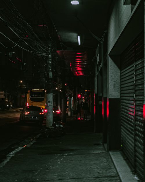 Free A dimly lit urban street at night with buses and cars. Atmospheric and moody. Stock Photo