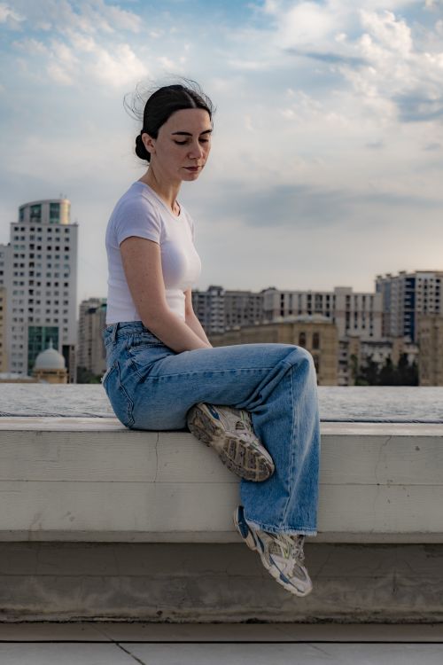 Contemplative Woman on Urban Rooftop at Dusk · Free Stock Photo