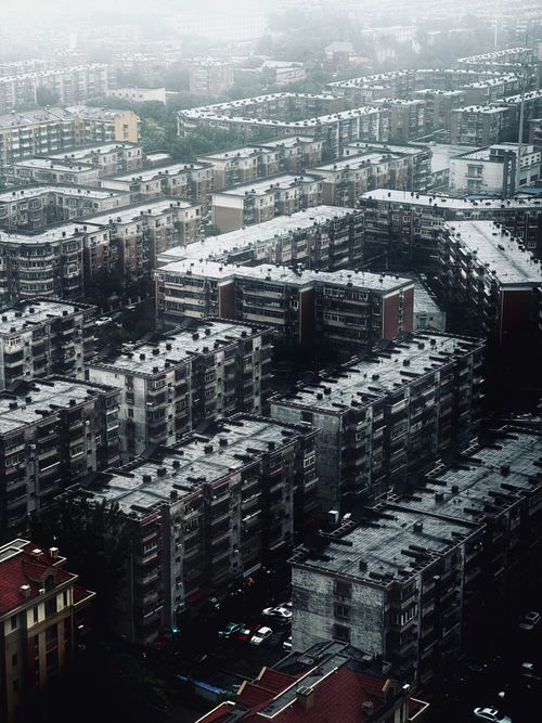 Free Aerial shot of closely packed apartment blocks in a misty urban landscape. Stock Photo