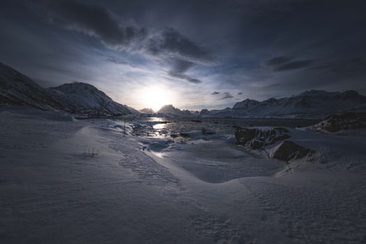 Captivating view of a serene snowy landscape with a breathtaking Arctic sunset captured in winter.