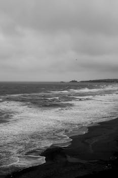 Dramatic black and white seascape view of Şile's shoreline under cloudy skies.