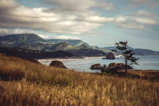 Beautiful view of Cannon Beach, Oregon, featuring Haystack Rock with coastal mountains in the background.