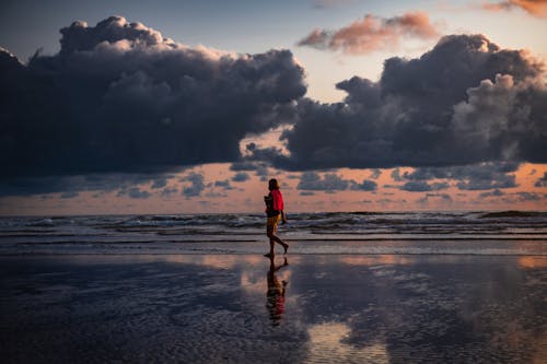 Person Walking on Seashore