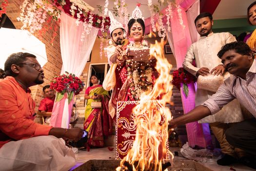 Vibrant Bengali wedding ritual in Kolkata, capturing a couple's sacred vows by the ceremonial fire.