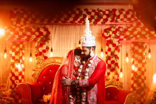 A joyous Bengali couple celebrating their wedding in Kolkata, India.
