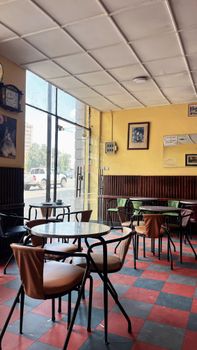 Empty vintage café with retro decor and checkered floor, creating a cozy ambiance.