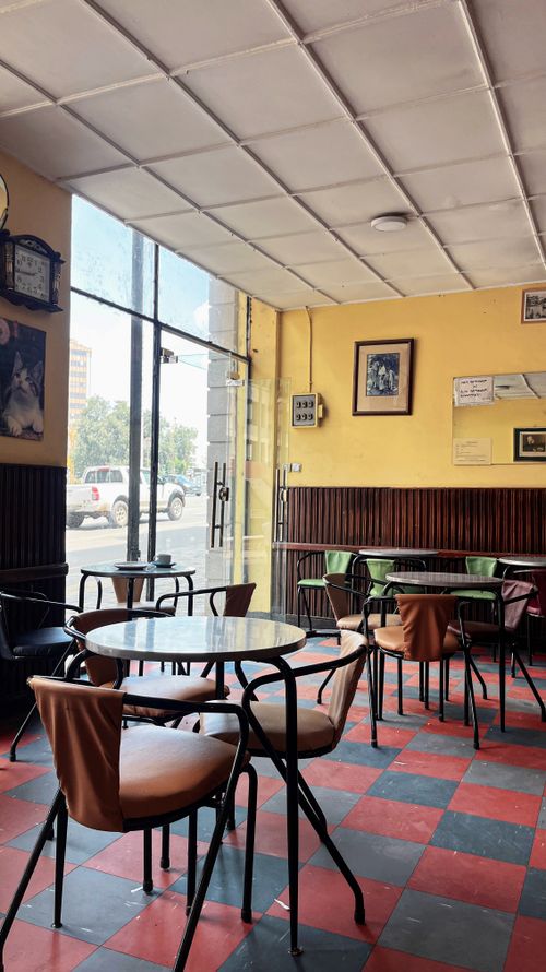 Free Empty vintage café with retro decor and checkered floor, creating a cozy ambiance. Stock Photo
