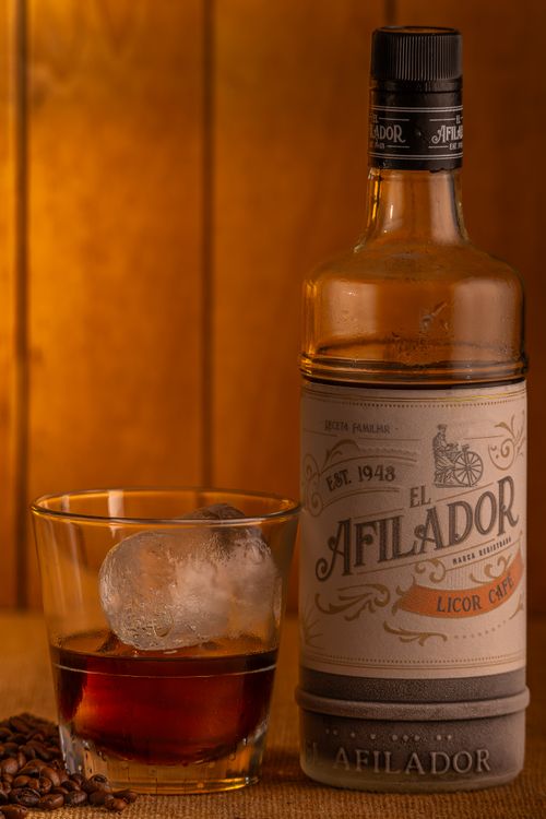 Free Close-up of El Afilador Licor Café bottle and glass with ice, perfect for drink enthusiasts. Stock Photo