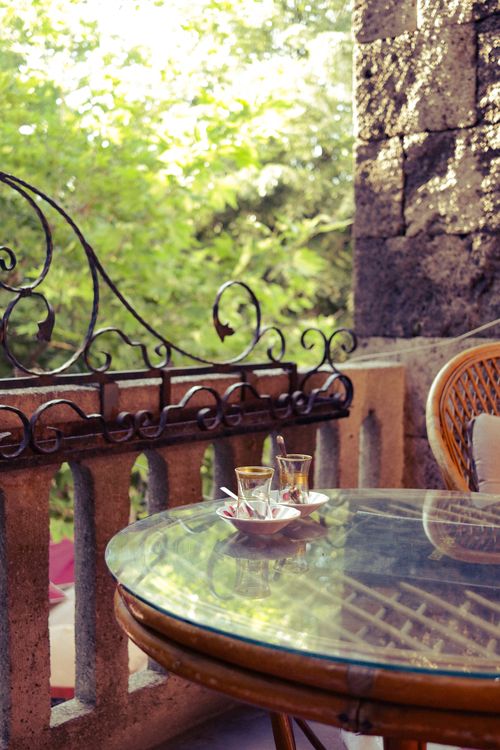 Free Peaceful outdoor patio view with tea glasses on a glass table, ideal for relaxation. Stock Photo