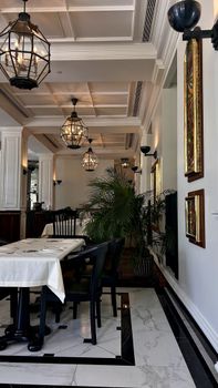 Stylish dining room with classic lighting, marble floors, and elegant furnishings.