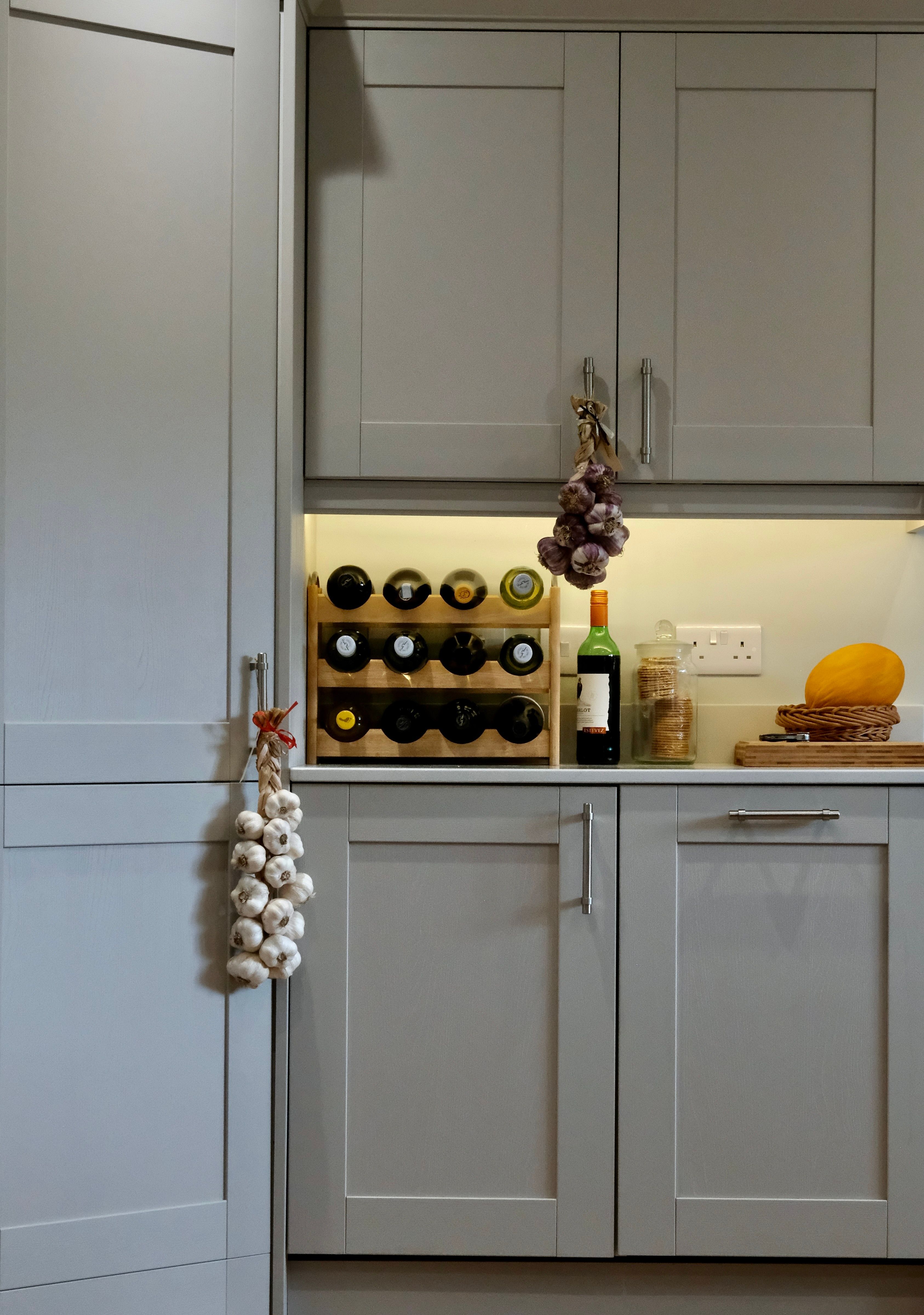 Cozy Kitchen Interior with Wine Rack and Garlic · Free Stock Photo