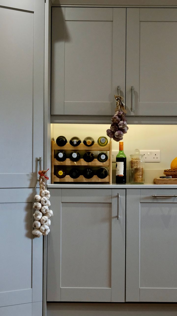 A kitchen wine rack integrated coffee cabinet holding bottles of cold brew and coffee liqueurs