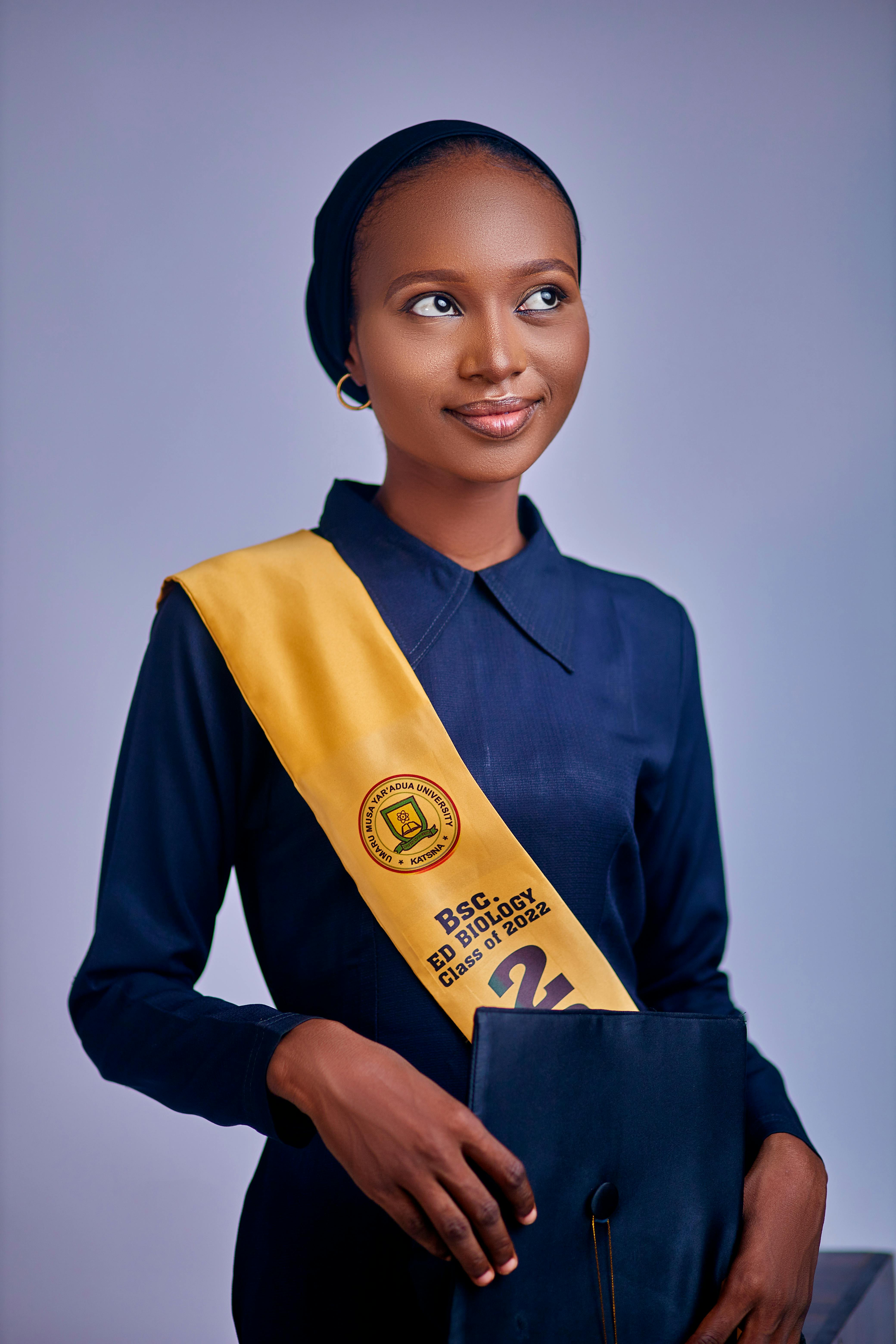 Excited graduate in academic regalia holding diploma, symbolizing achievement.