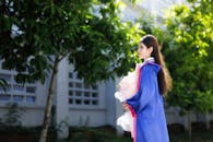 Young Graduate Holding Bouquet Outdoors