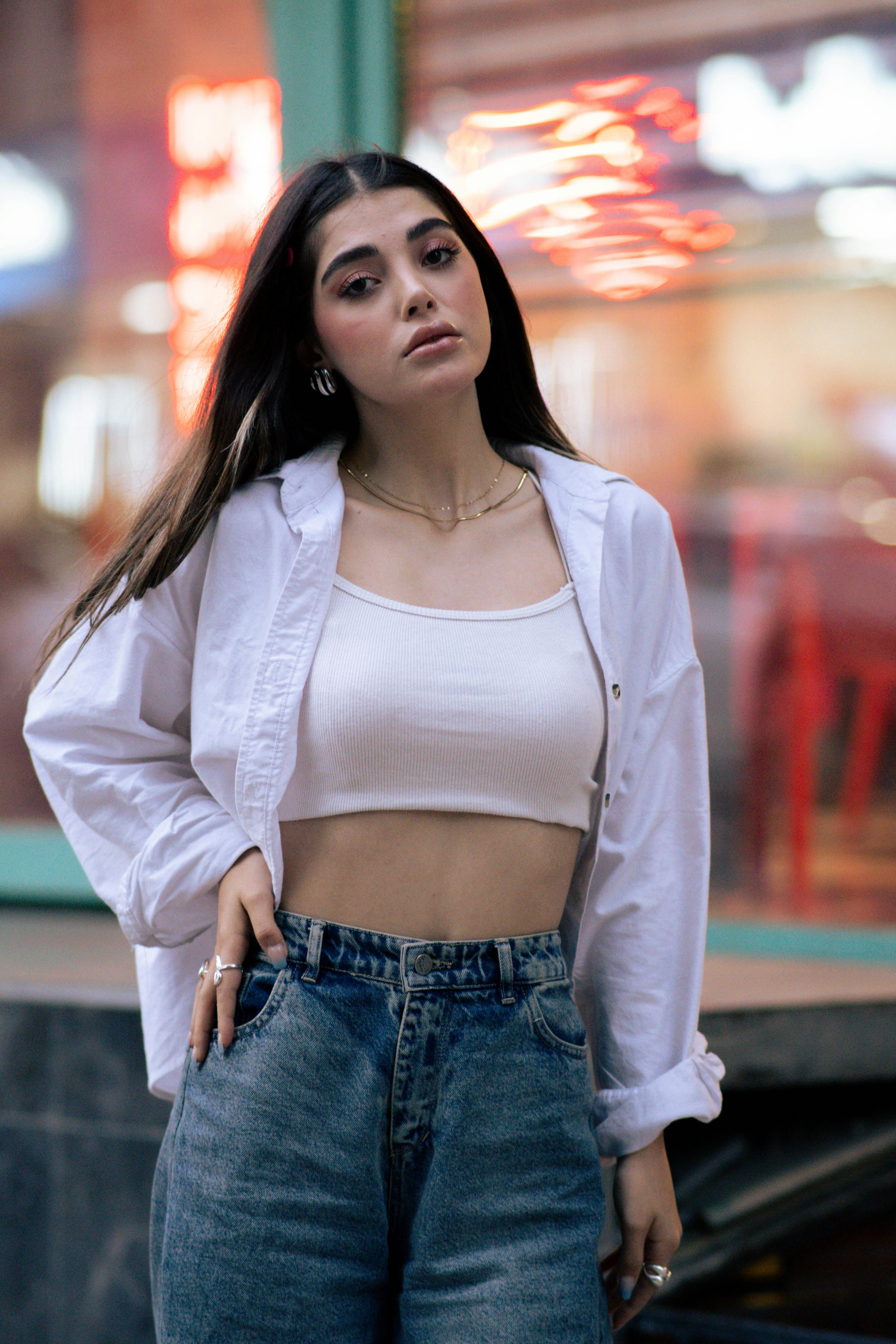 Stylish portrait of a young woman in trendy attire against a city backdrop.