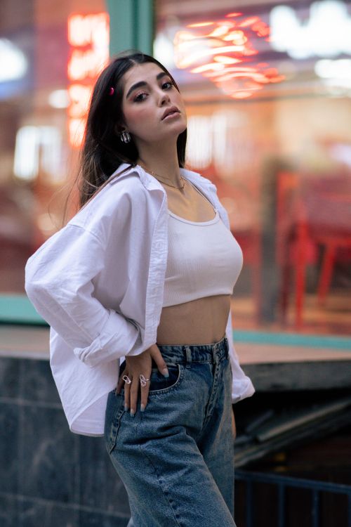 Free A fashionable woman poses confidently outdoors in Tehran, blending urban style with a chic white outfit. Stock Photo
