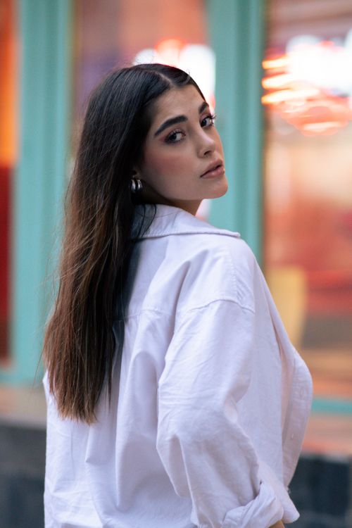 Free Elegant woman with long hair posing in a city setting, showcasing modern fashion. Stock Photo