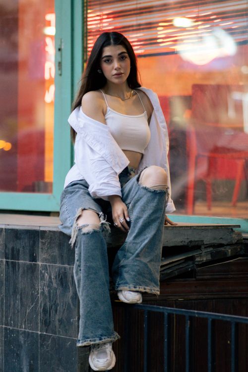 Free Stylish young woman sitting outdoors in Tehran, showcasing urban fashion trends. Stock Photo