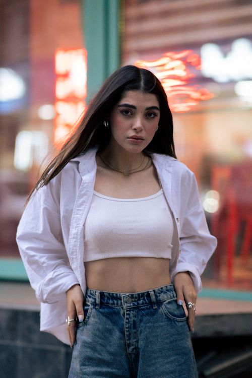 Free Portrait of a fashionable woman in Tehran with vibrant city lights in the background. Stock Photo