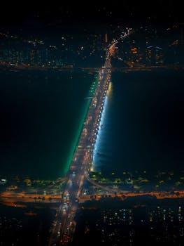High-angle night shot of a brightly lit bridge spanning across a river in Seoul, South Korea.