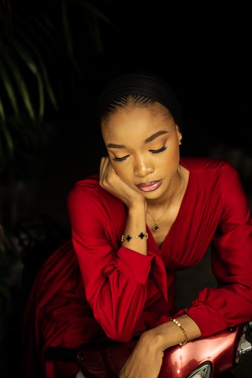 Free Portrait of a contemplative woman in a red dress, evoking elegance and tranquility. Stock Photo