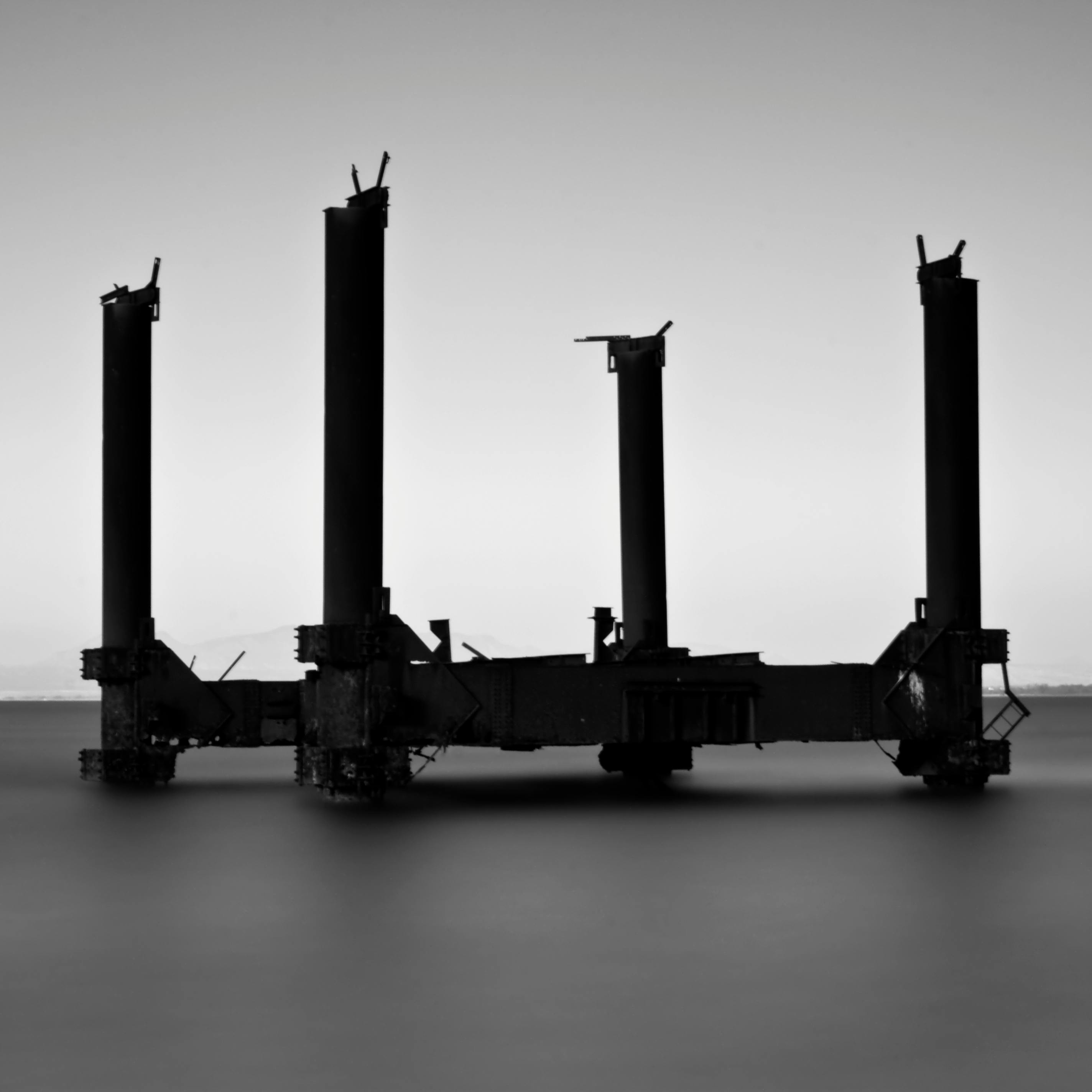 Ücretsiz Gemikonağı'nda sisli bir denizin üzerindeki terk edilmiş bir sanayi platformunun hüzünlü siyah beyaz fotoğrafı. Stok Fotoğraflar