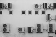 Black and white image of air conditioners mounted on a building facade in Córdoba, Argentina.