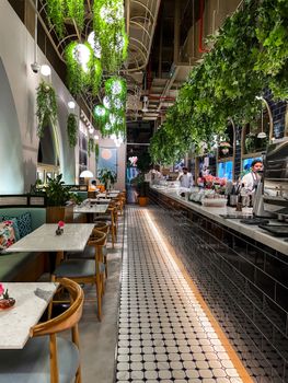 Stylish restaurant with lush greenery and elegant decor. Perfect for dining.