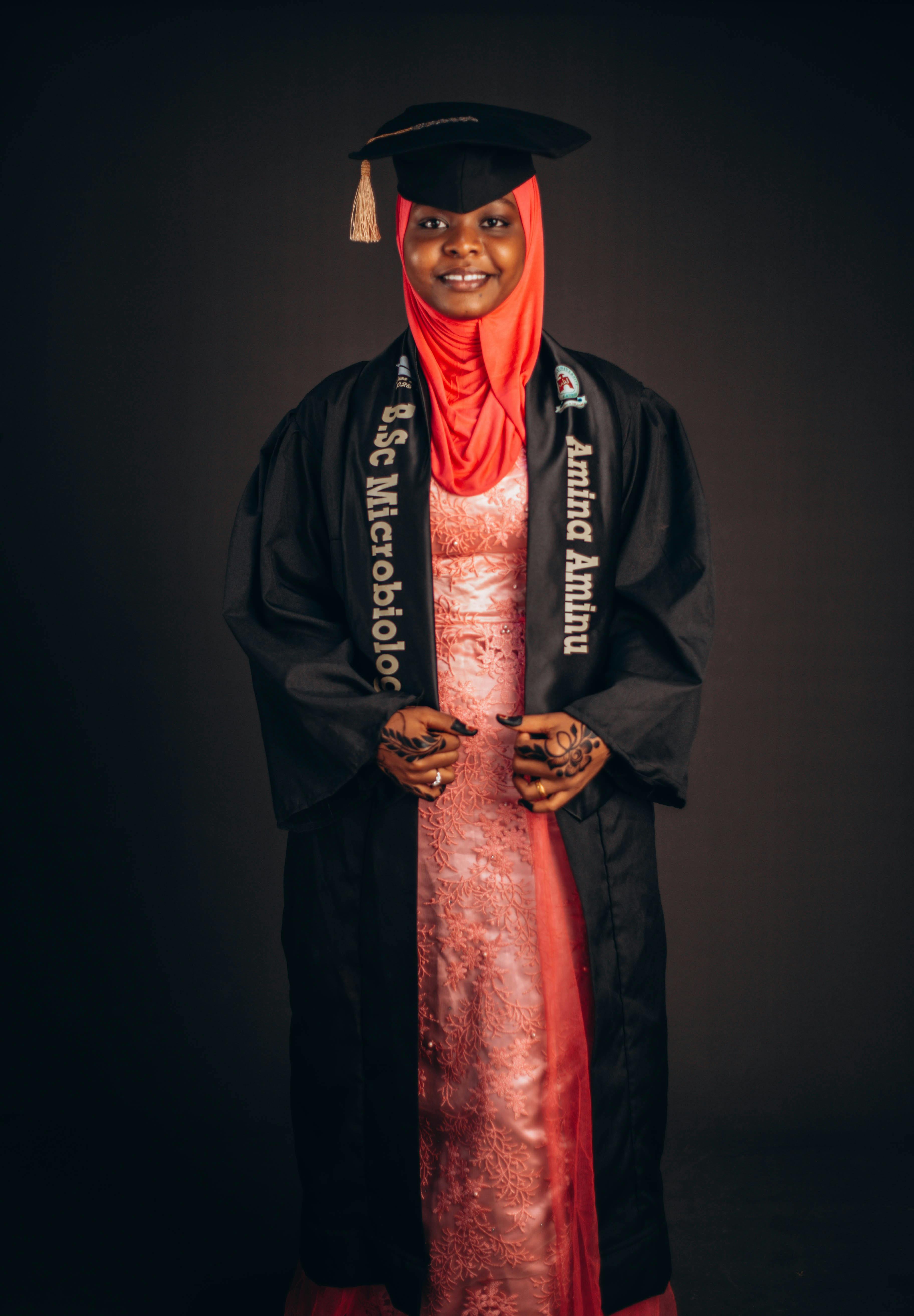 Graduate woman in hijab with a degree in microbiology, celebrating success.