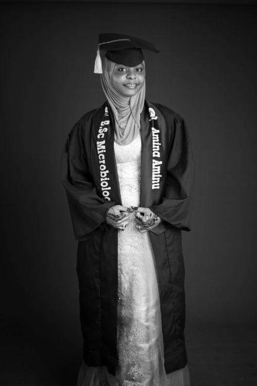Free A young woman wearing a hijab proudly poses in her graduation gown and cap. Stock Photo