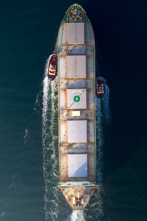 Aerial Photography of a Cargo Ship and Tag Boats