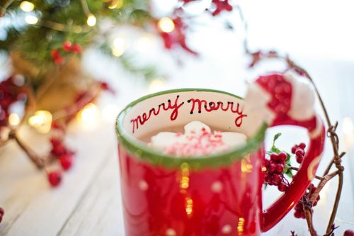 Free Close-up of a Christmas-themed mug with a hot beverage, surrounded by festive decorations. Stock Photo