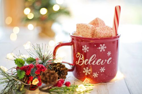 Free Red mug with marshmallows and candy cane, holiday decorations and lights. Stock Photo