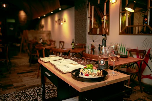 Cozy restaurant table with gourmet dish and wine, creating a warm dining ambiance.