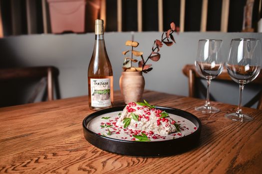 A stylish restaurant table setting with pomegranate dish and wine bottle, perfect for fine dining.